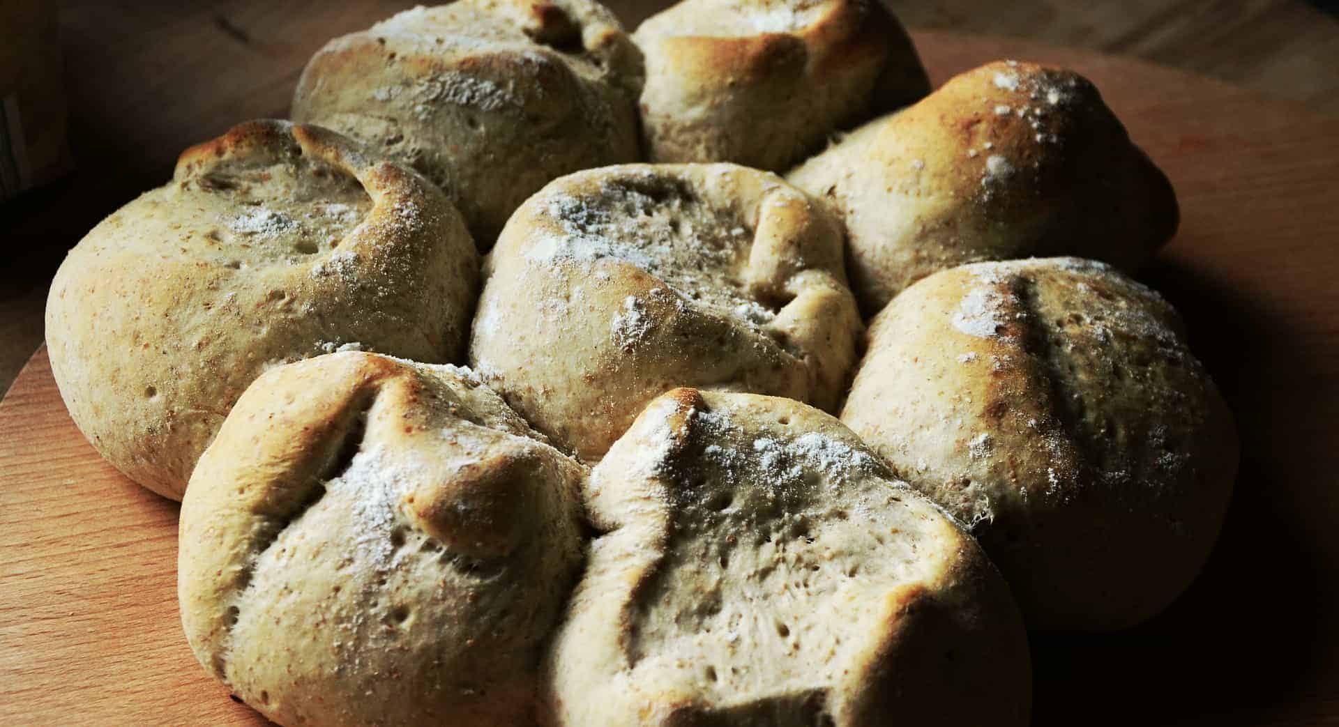 fresh baked dinner rolls on a wooden cutting board