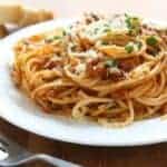 white plate of pasta with Italian pasta sauce and meat