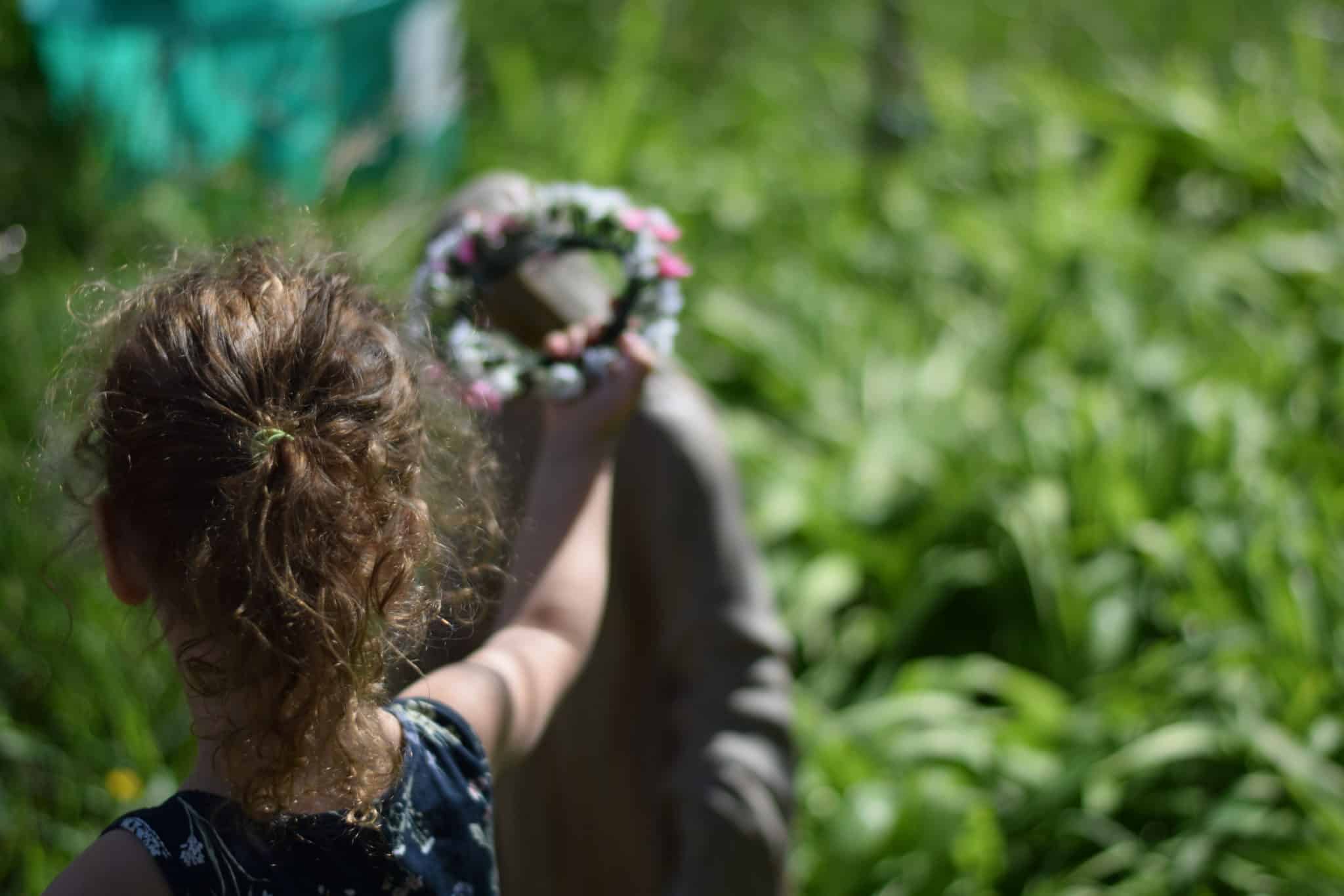 little girl crowing the outdoor Mary statue in the garden