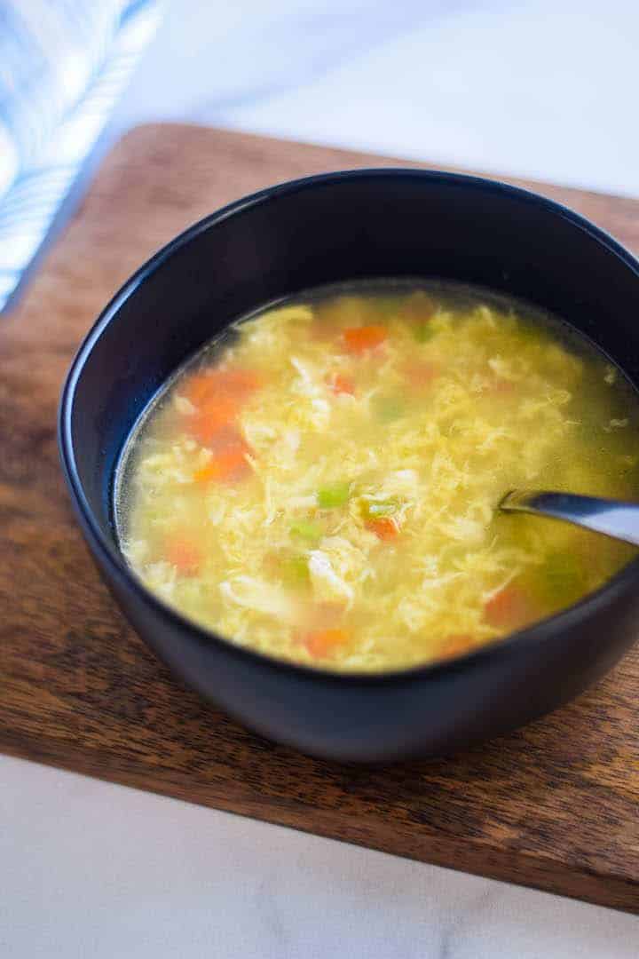 egg drop soup in a black bowl