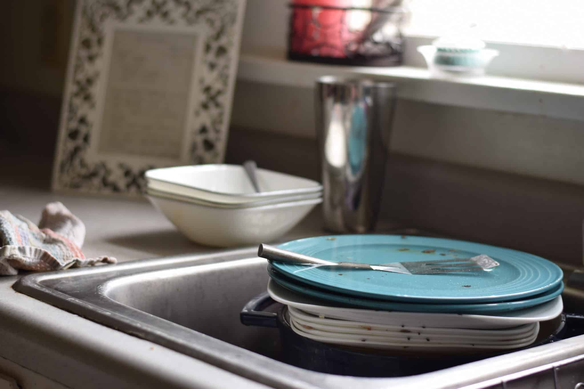 pile of dirty dishes in sink