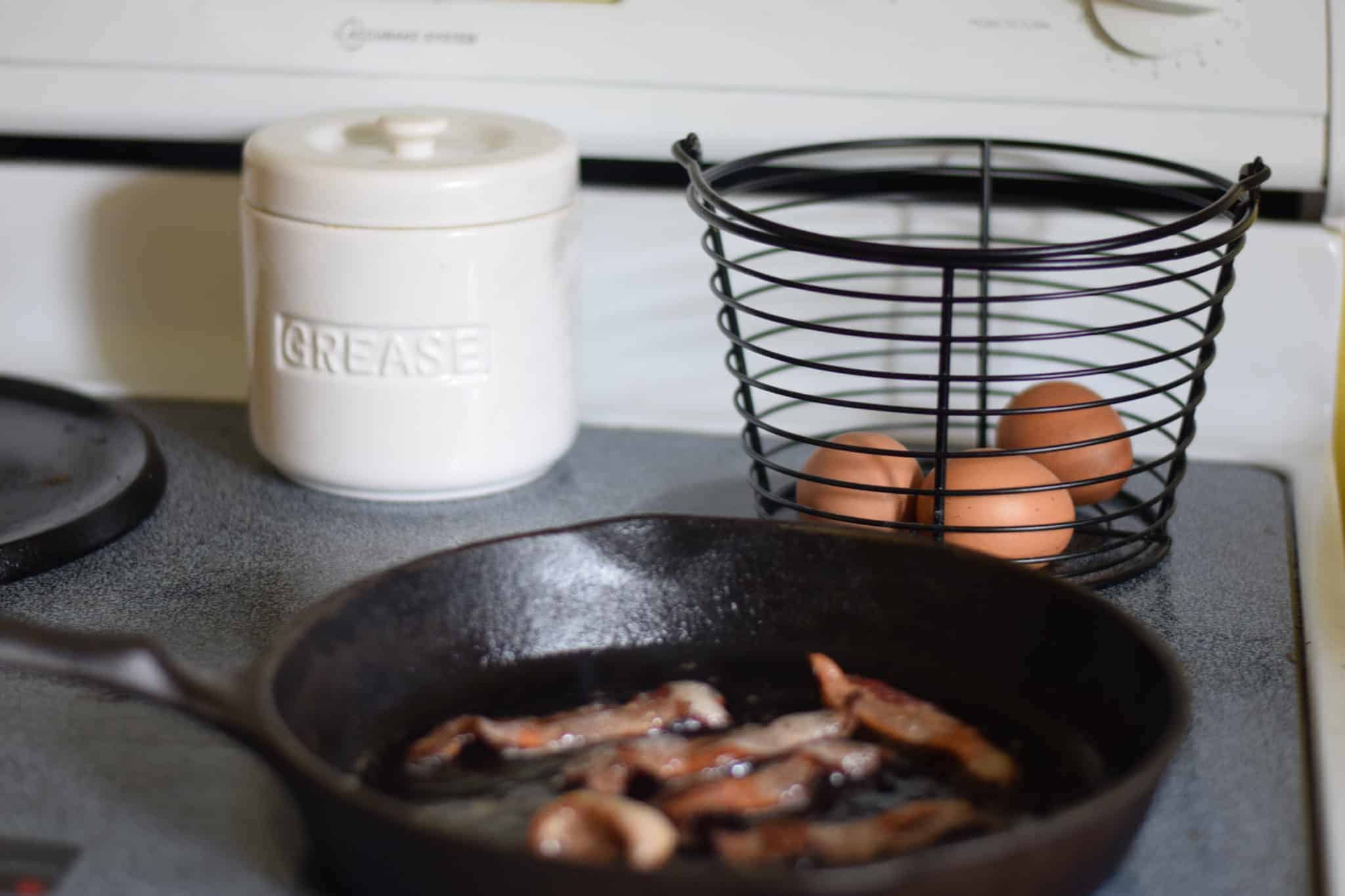 bacon cooking in a cast iron skillet