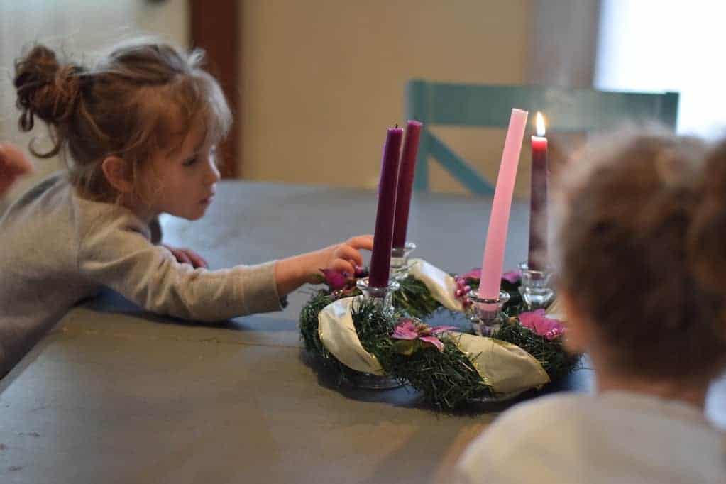 two little girls admiring the advent wreath at the dining room table 