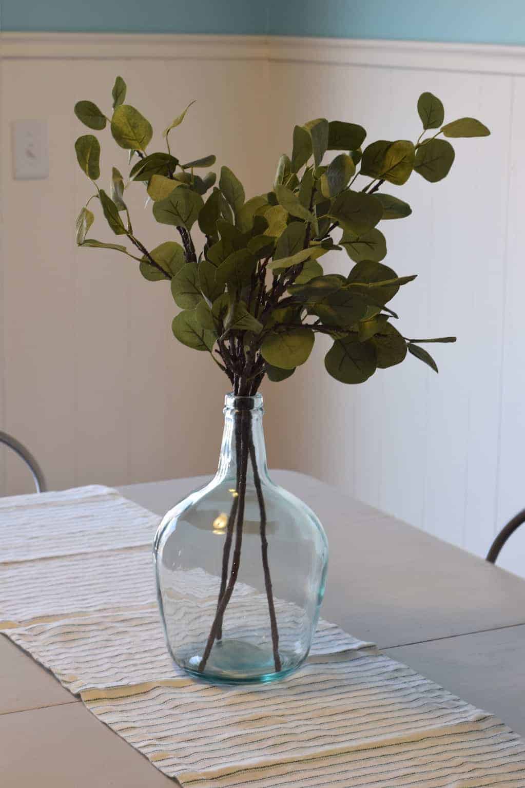 eucalyptus leaves and demijohn on the farmhouse dining room table