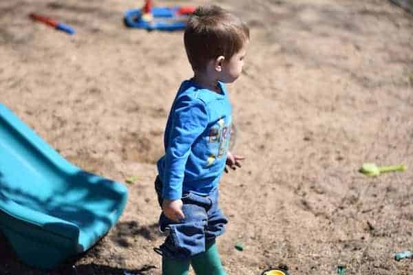 little boy playing in a sand box