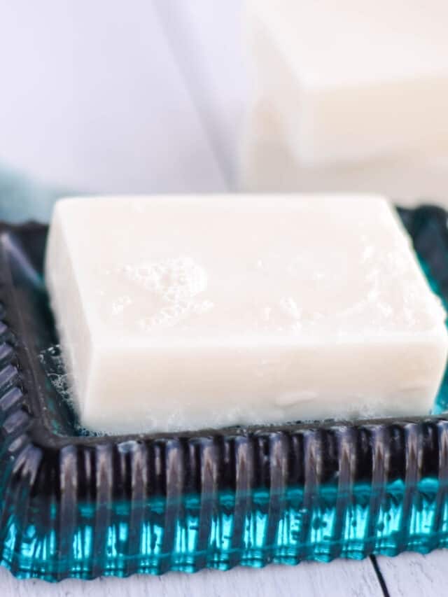 homemade goat milk soap bar on a teal blue soap dish