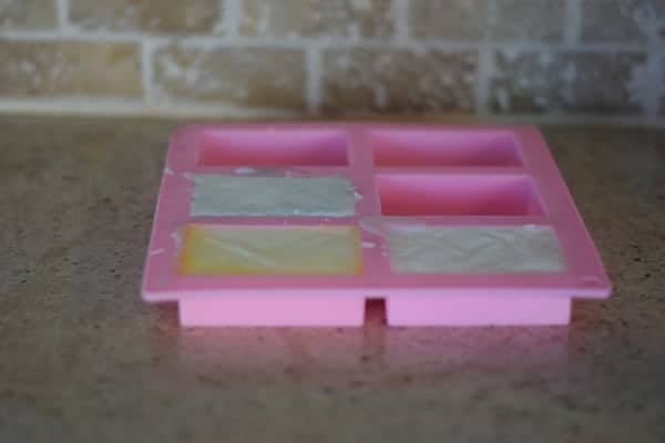 soap base with essential oils in a pink soap mold 