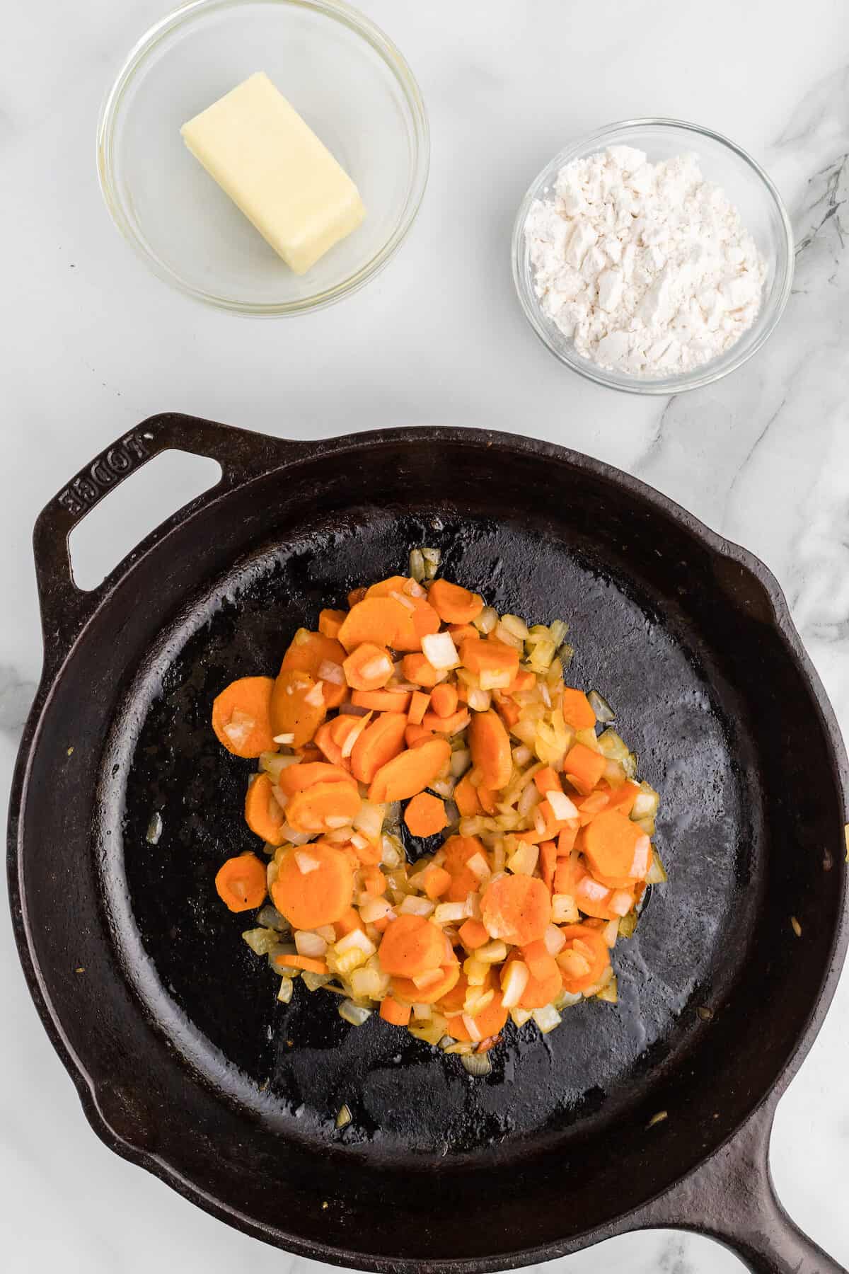 carrots and onions in a cast iron skillet.