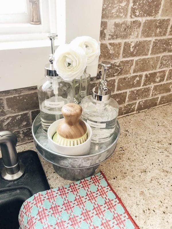 hand and dish soap in soap dispensers next to the kitchen sink