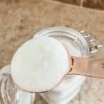dishwasher detergent in a copper measuring spoon