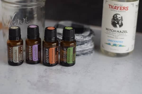 four essential oil bottles with with hazel