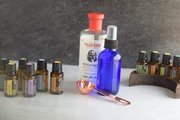 essential oil bottles, witch hazel, and blue glass spray bottle