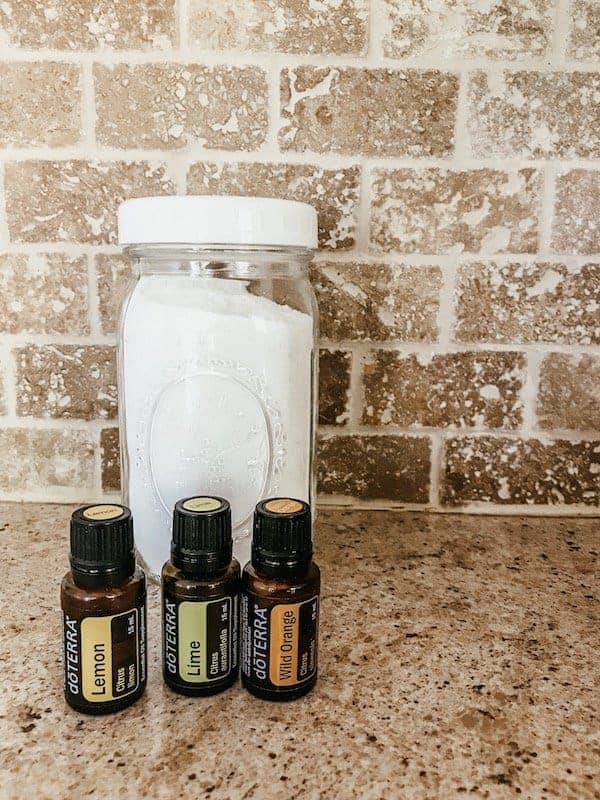 laundry detergent in a mason jar with essential oil bottles on countertop