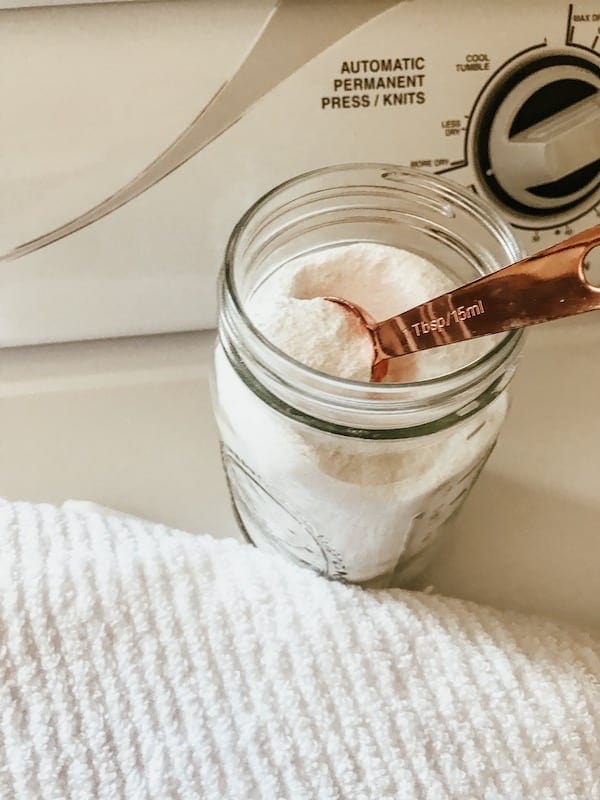 natural laundry detergent in a mason jar with a white towel and sitting on the dryer