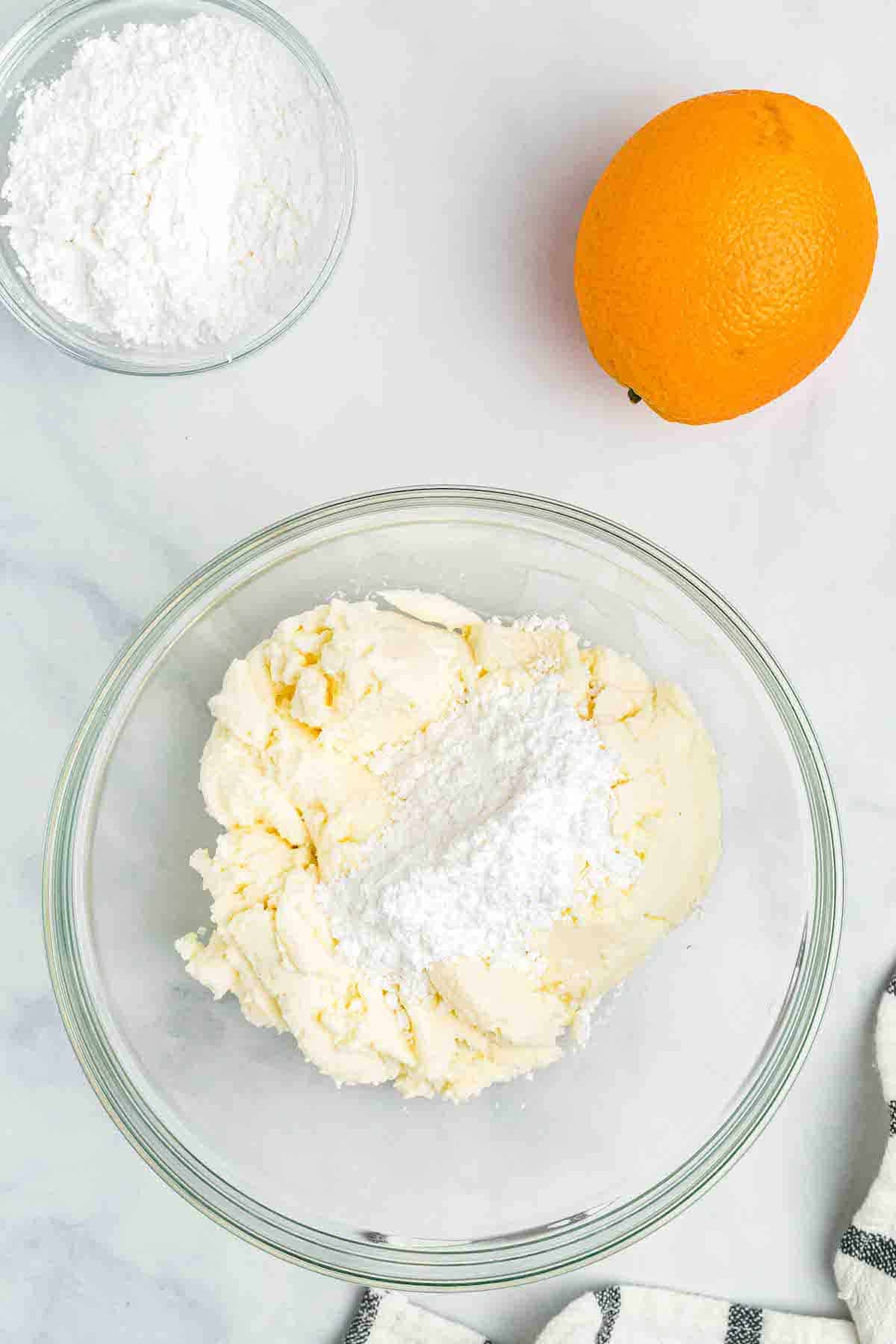 adding the powdered sugar to the ricotta cheese for the cannoli filling recipe.