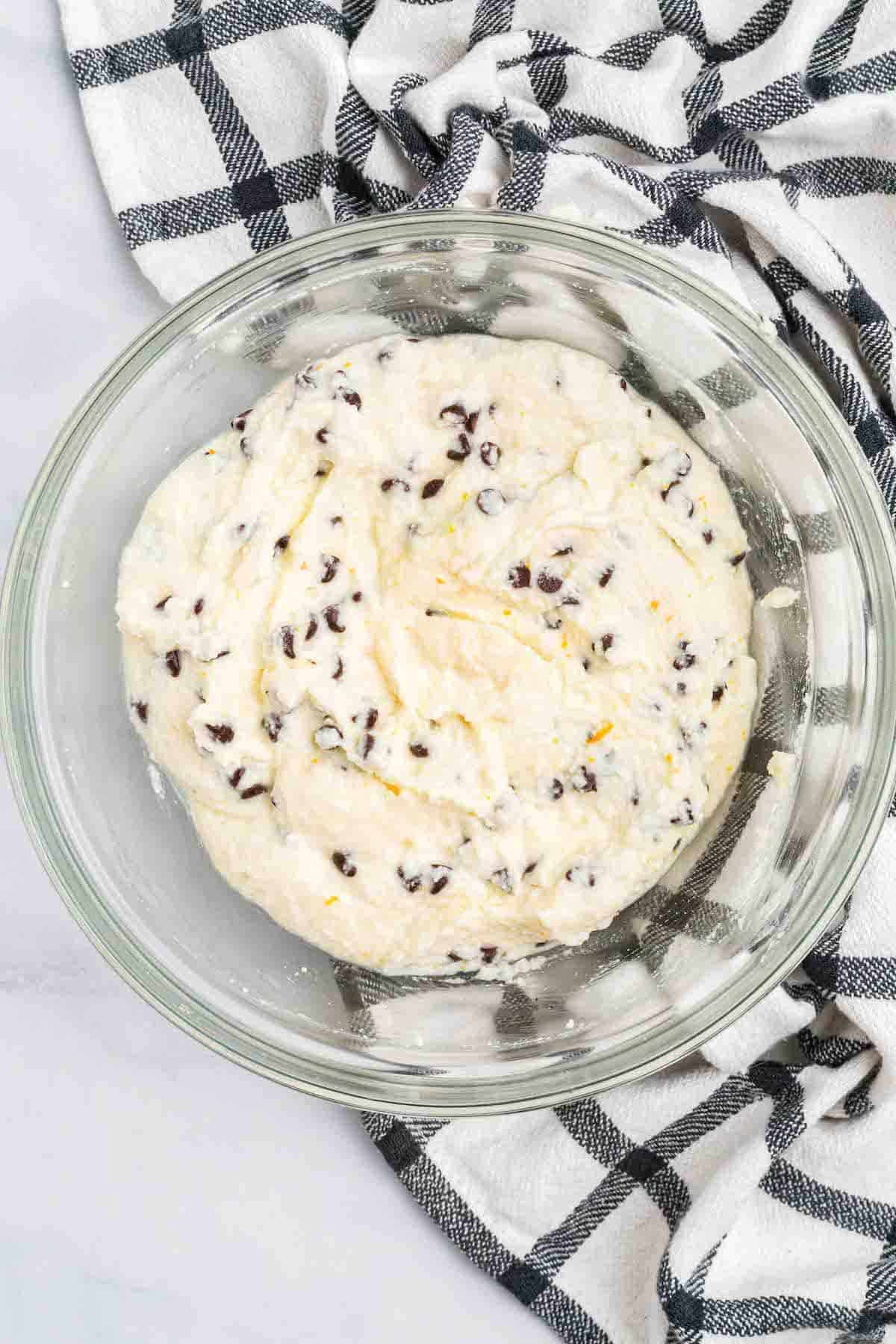 adding the chocolate chips to the cannoli filling dip.