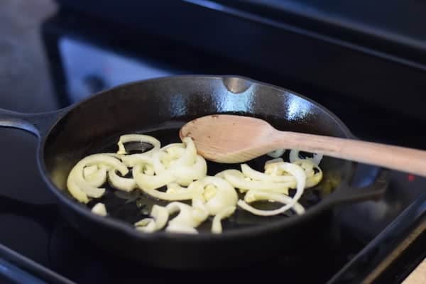 onions sautéing in a cast iron skillet