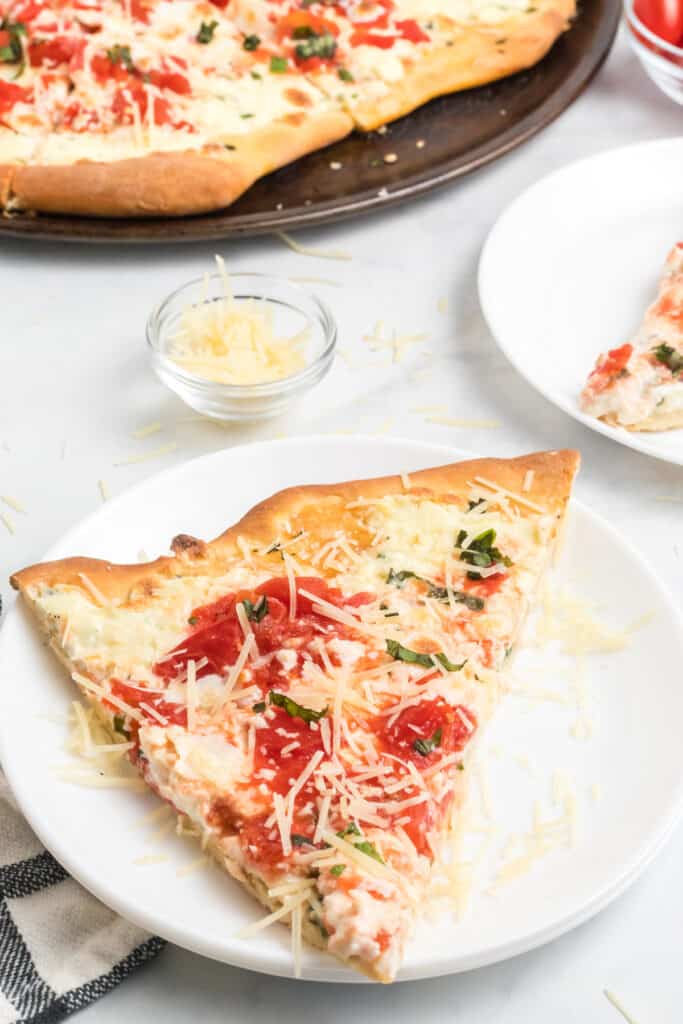 white plates of tomato, basil, ricotta pizza