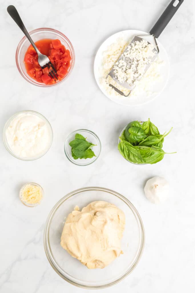 basil and ricotta pizza ingredients in little bowls