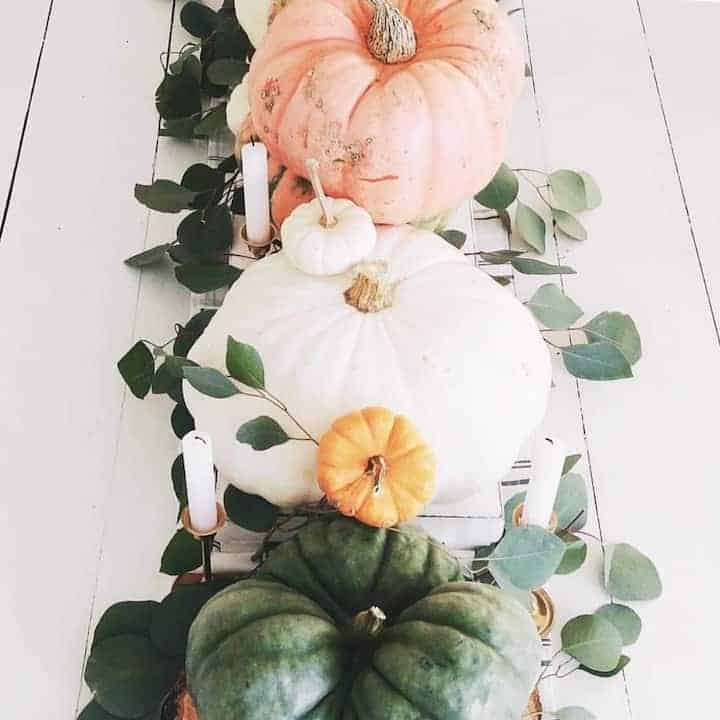 pumpkins and candles on table runner
