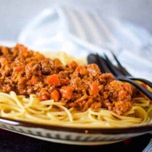 beef ragu over spaghetti on a platter