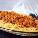 beef ragu over spaghetti on a platter