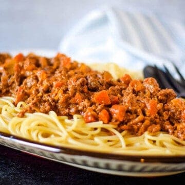 beef ragu over spaghetti on a platter