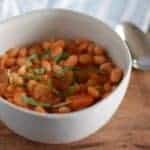 simple greek bean soup in a white bowl with a spoon