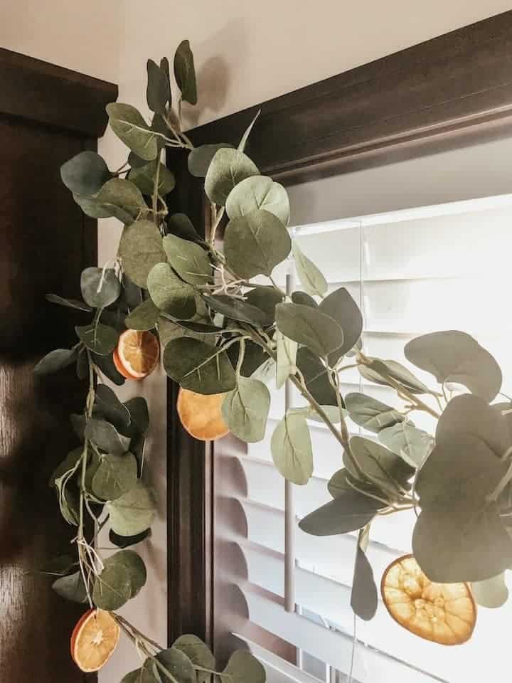 eucalyptus garland with dried oranges hanging from kitchen window
