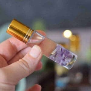 essential oil roller bottle with amethyst rocks