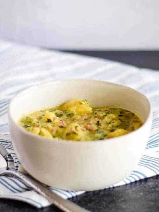 Italian sausage soup with potatoes in a white bowl