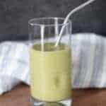 moringa smoothie in a glass with stainless steel straw