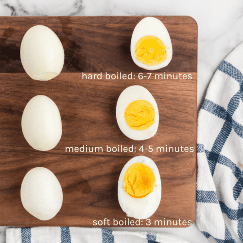 Ninja Foodi hard boiled eggs with slices on a wooden board and cook times below.