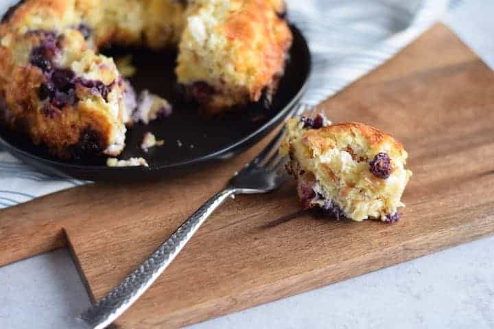 blueberry cream cheese bread pudding on a black plate 