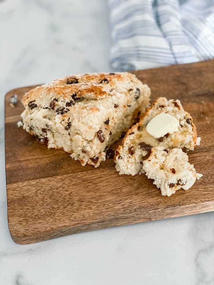 easy Irish soda bread resting on a wooden board with a slice of butter