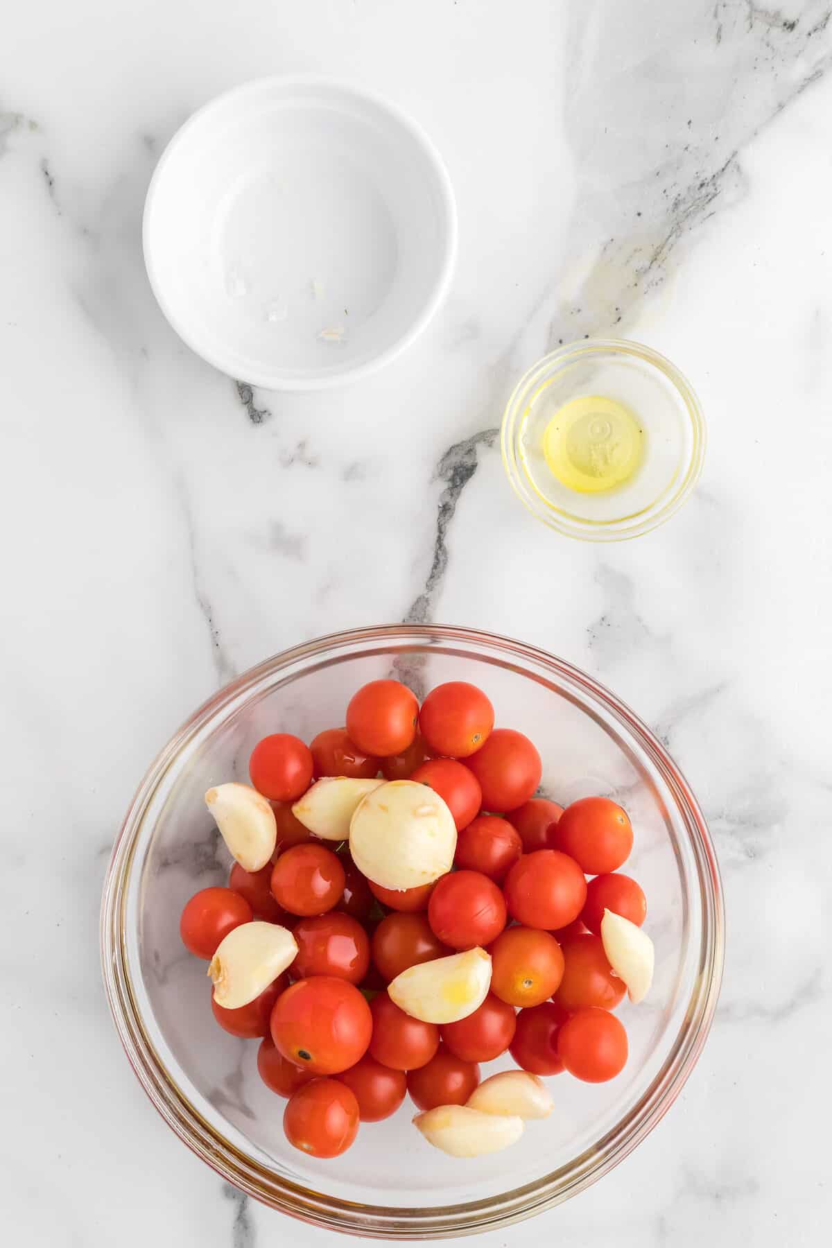 large bowl with cherry tomatoes and garlic cloves.