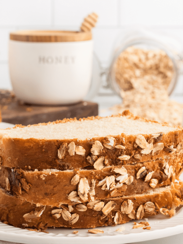 slices of honey oat bread on a white plate.