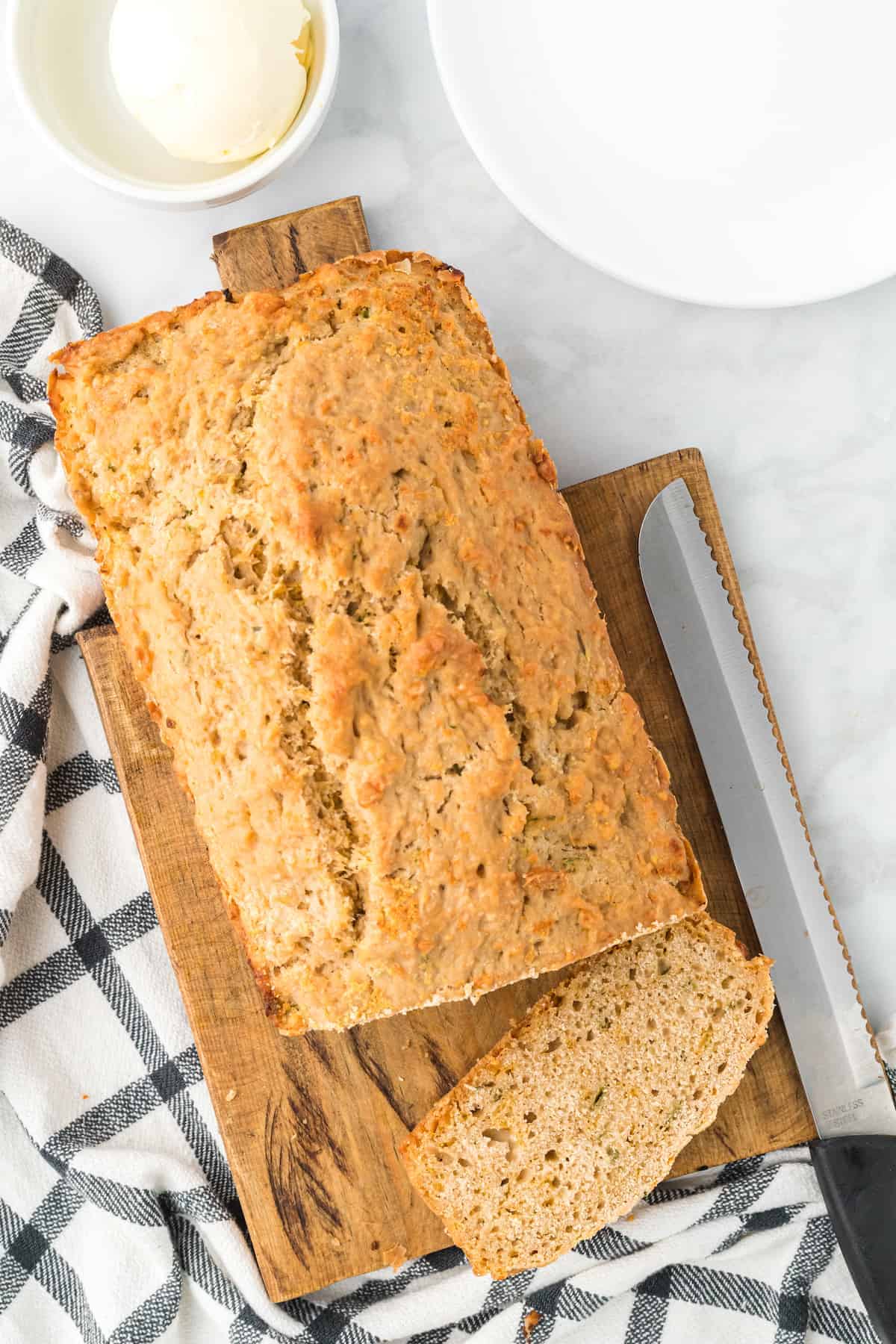 loaf of cheddar beer bread on a wooden cutting board