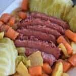 Ninja Foodi corned beef and cabbage on a white platter with potatoes and carrots