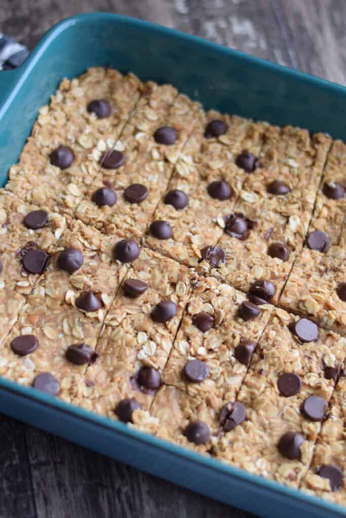 cutting the granola bars inside a blue baking dish