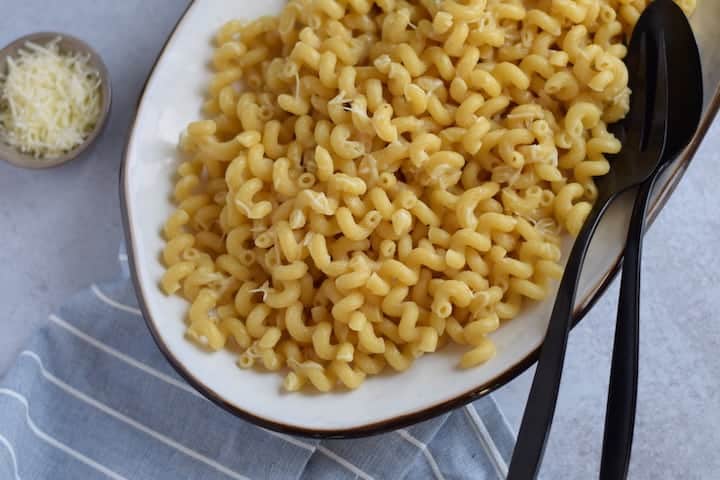 white platter with cheesy butter pasta 