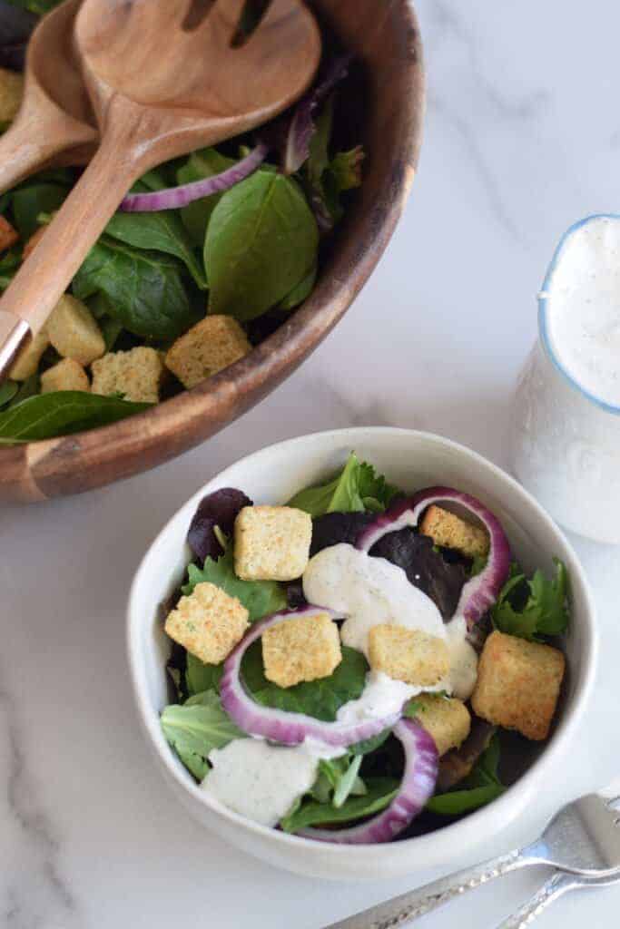 buttermilk ranch dressing on a salad in a white bowl