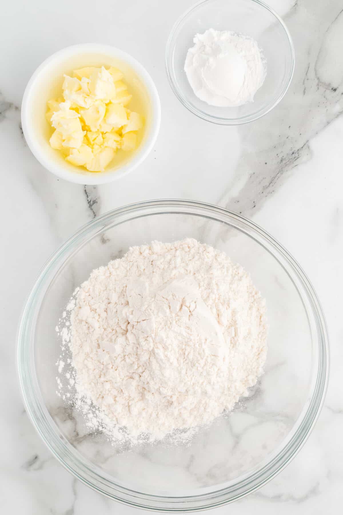 dry ingredients and butter in glass bowls.