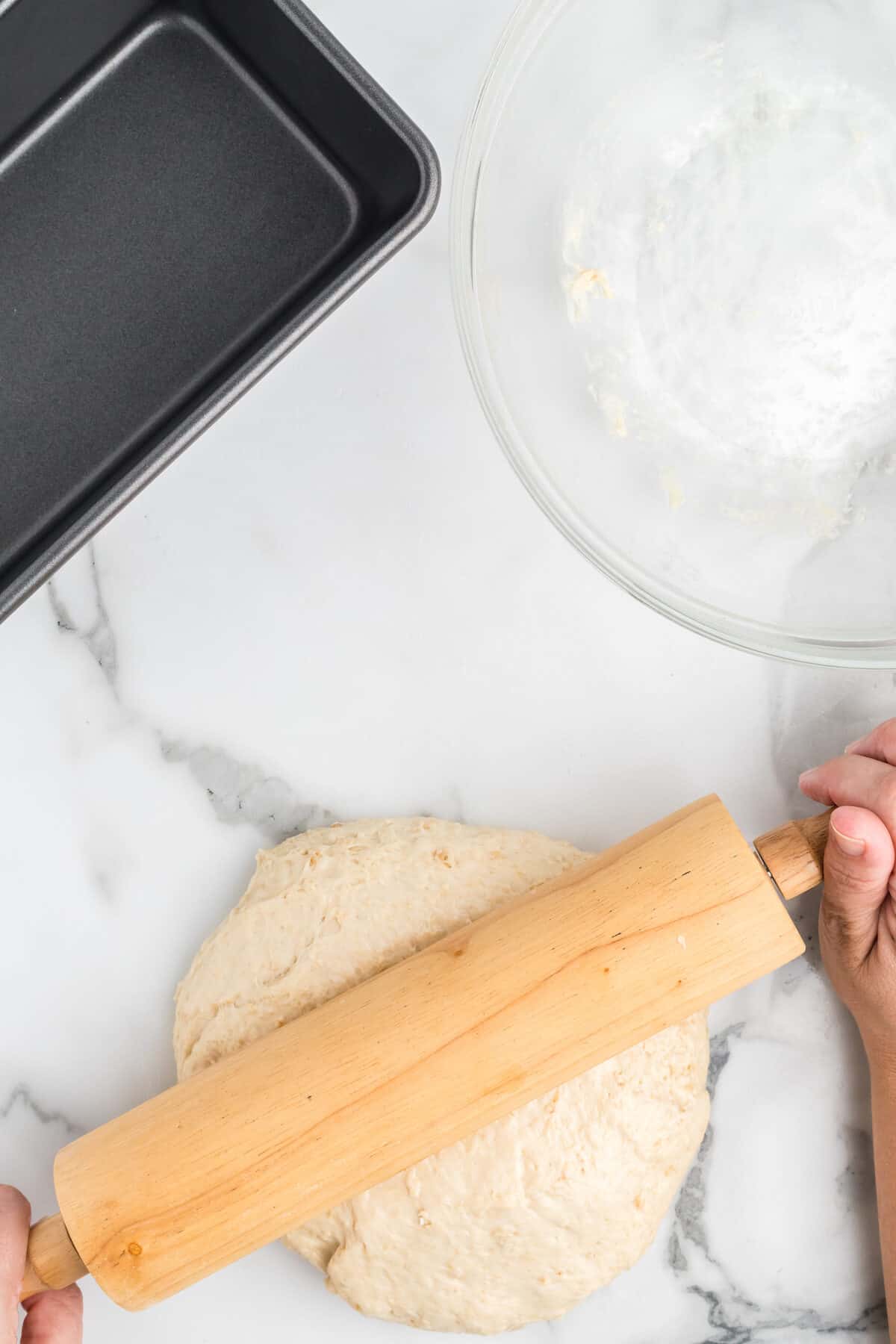 rolling out the bread dough with a rolling pin.