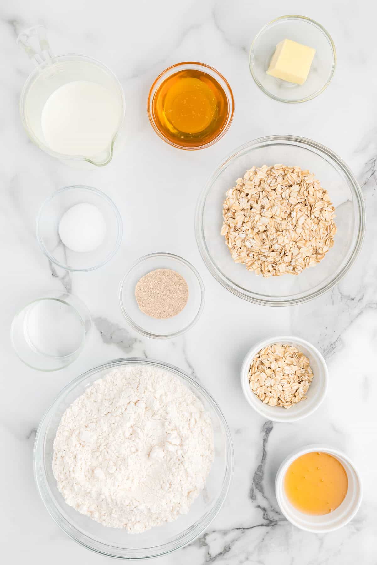 ingredients for honey oat bread in small bowls.