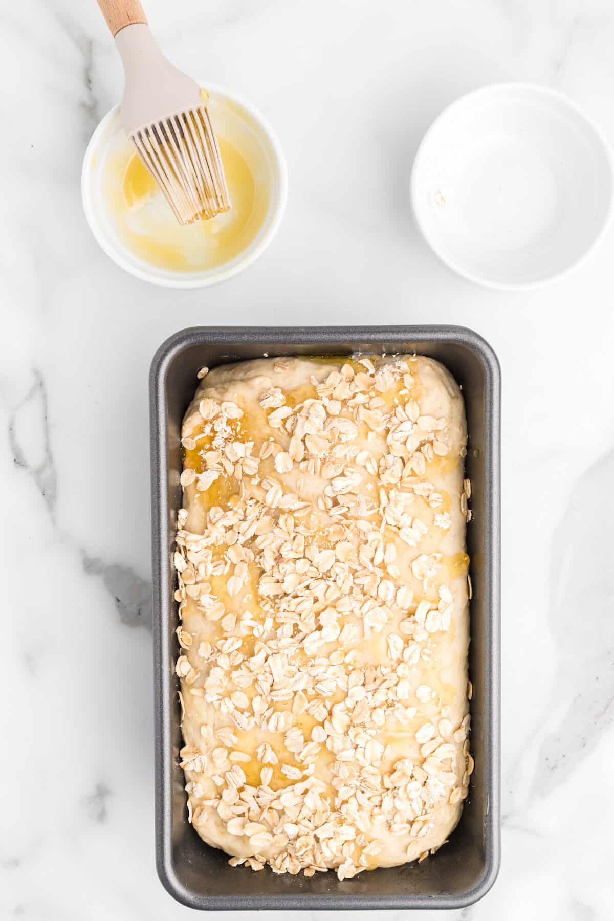 oats over the top of the honey on the bread loaf. 