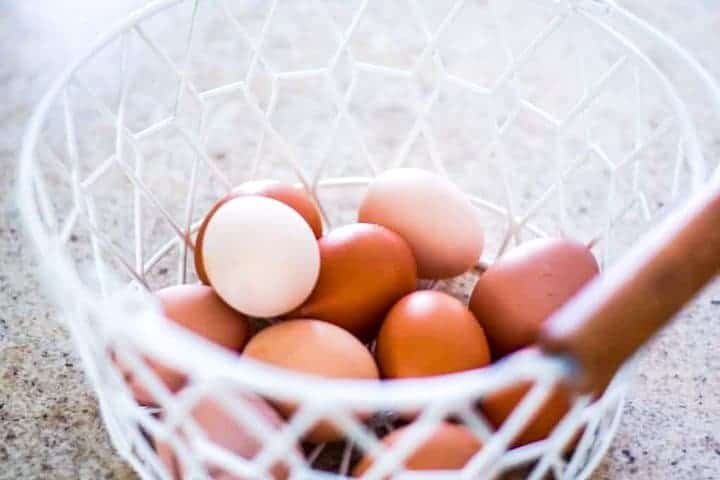 white wire basket full of farm fresh chicken eggs