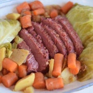 white platter filled with Ninja Foodi corned beef, carrots, cabbage, and potatoes