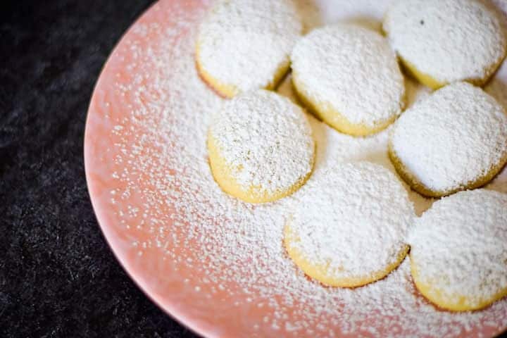 pink plate with greek butter cookies and powdered sugar topping