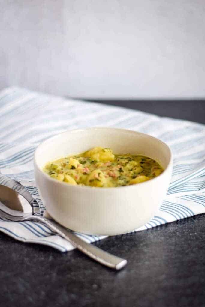 Italian sausage soup with potatoes in a white bowl 